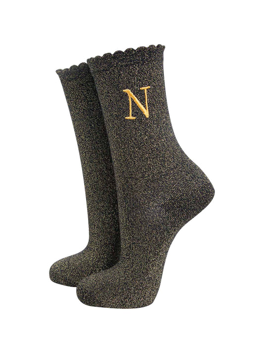 black ankle socks with a scalloped cuff, with an all over gold glitter sparkle and an embroidered gold letter n on the ankle
