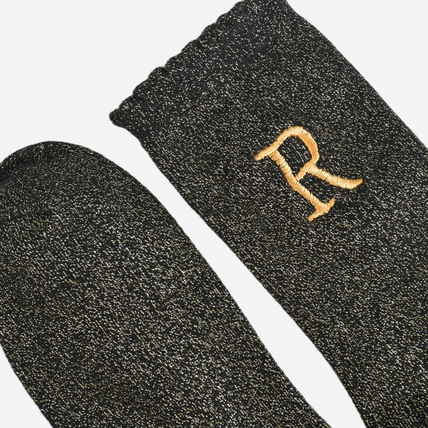 close up of the scalloped cuff on the socks, the toe is the same black and gold as the rest of the socks