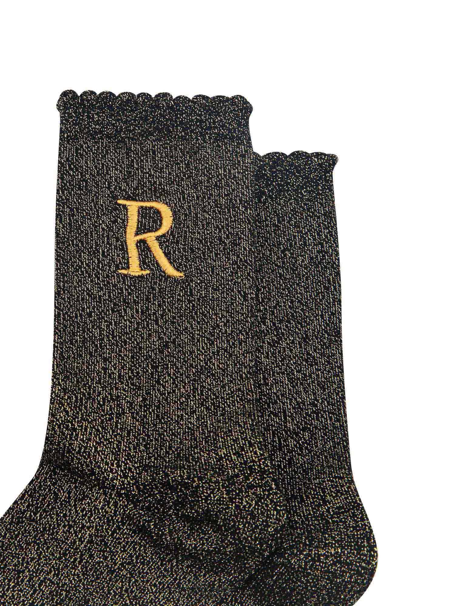close up of the gold embroidered capital letter r on the ankle of the socks
