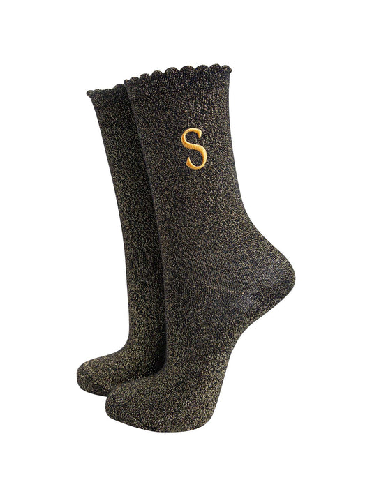 black ankle socks with a scalloped cuff, with an all over gold glitter sparkle and an embroidered gold letter s on the ankle
