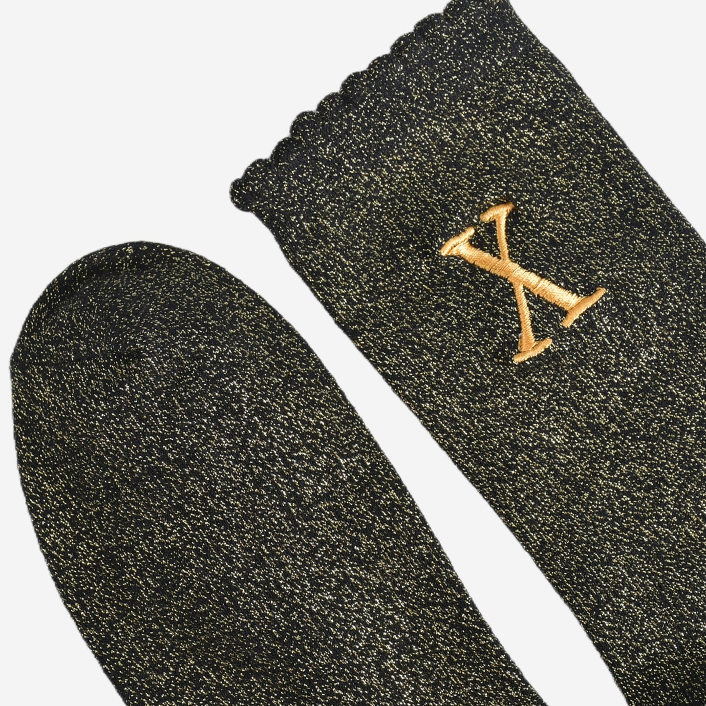 close up of the scalloped cuff on the socks, the toe is the same black and gold as the rest of the socks