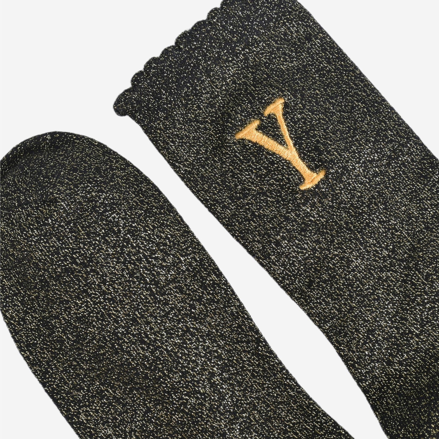 close up of the scalloped cuff on the socks, the toe is the same black and gold as the rest of the socks