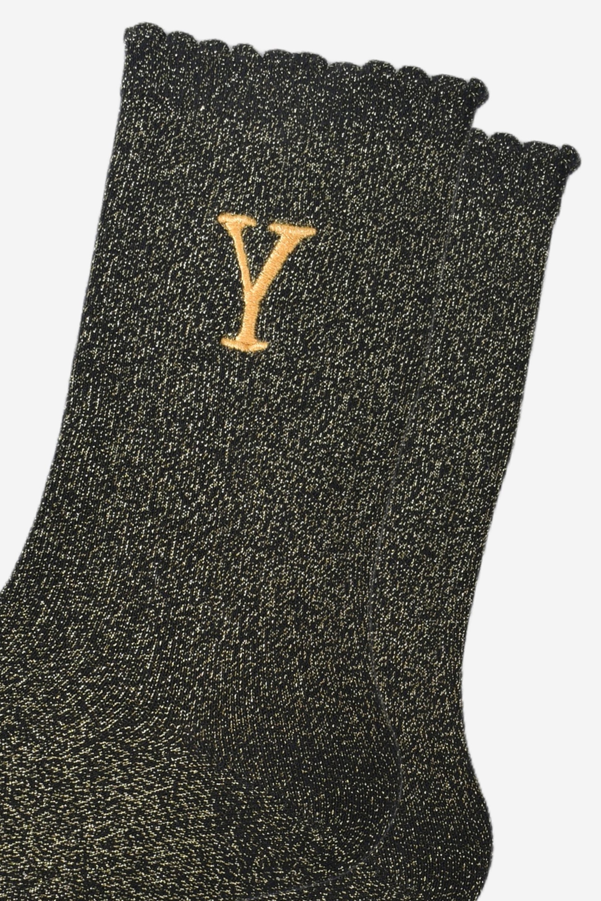 close up of the gold embroidered capital letter y on the ankle of the socks