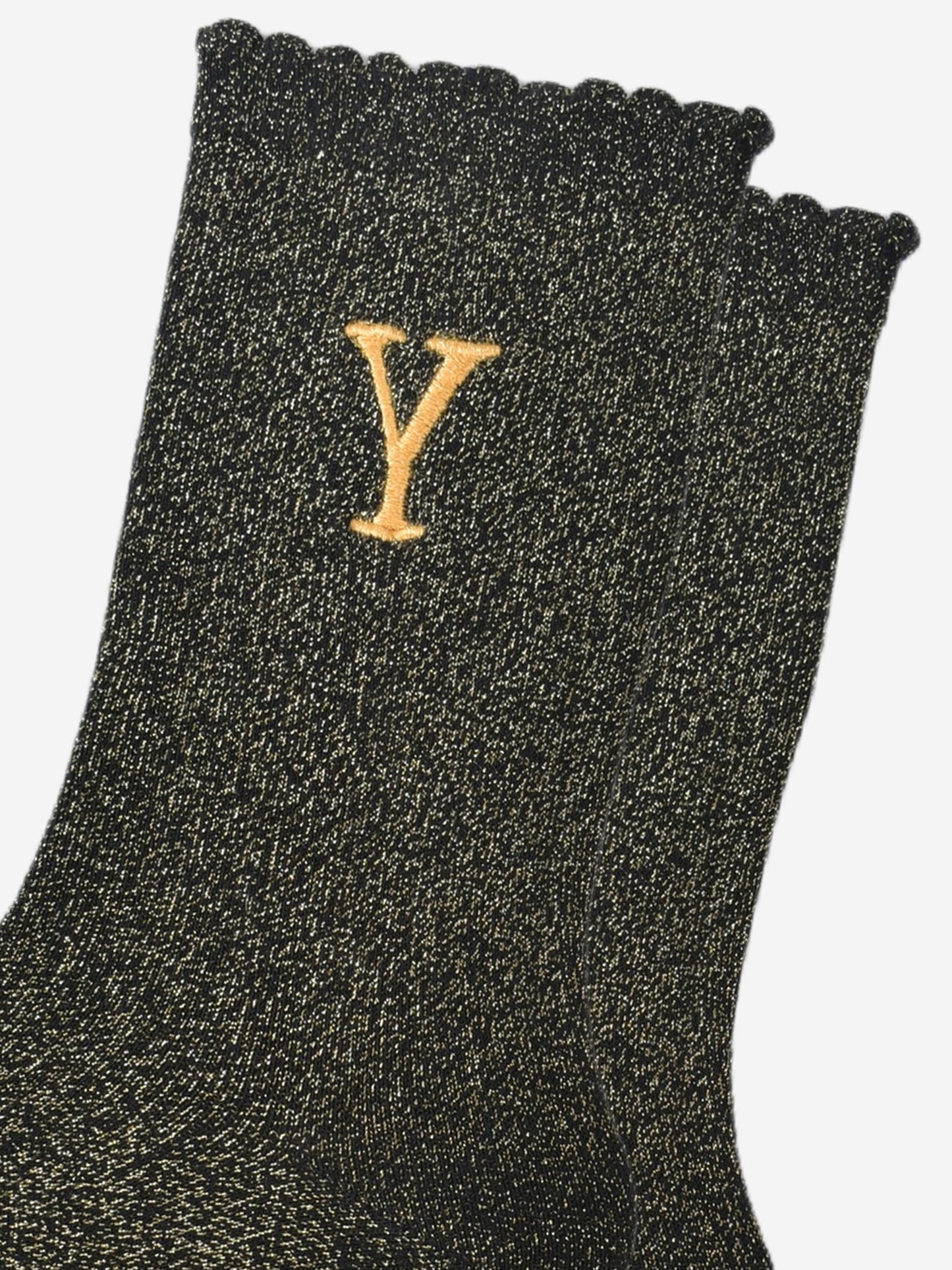 close up of the gold embroidered capital letter y on the ankle of the socks