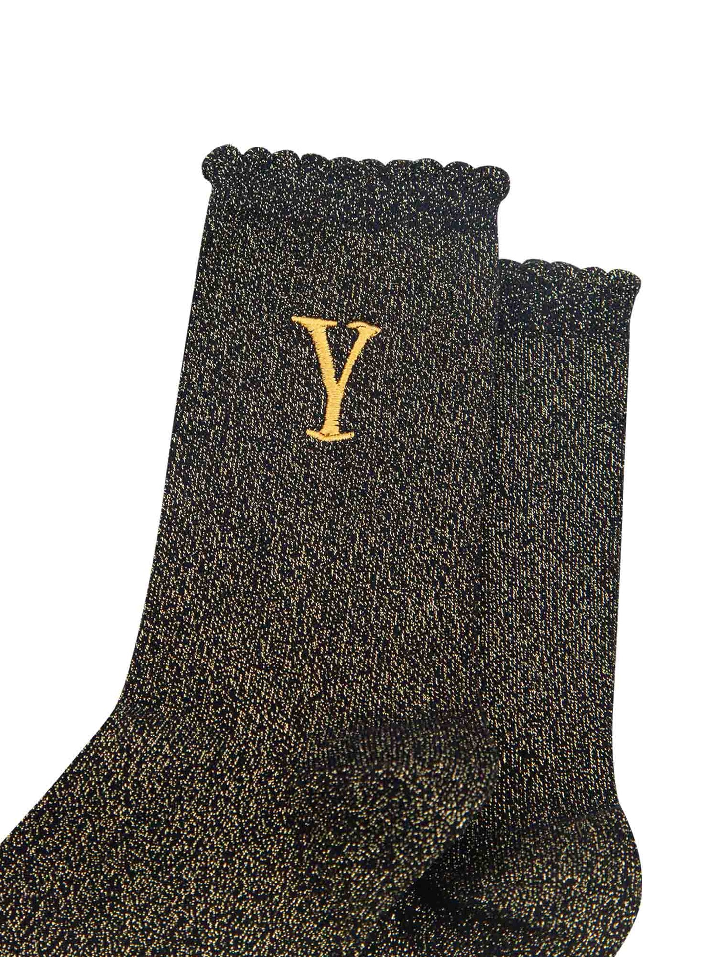 close up of the gold embroidered capital letter y on the ankle of the socks