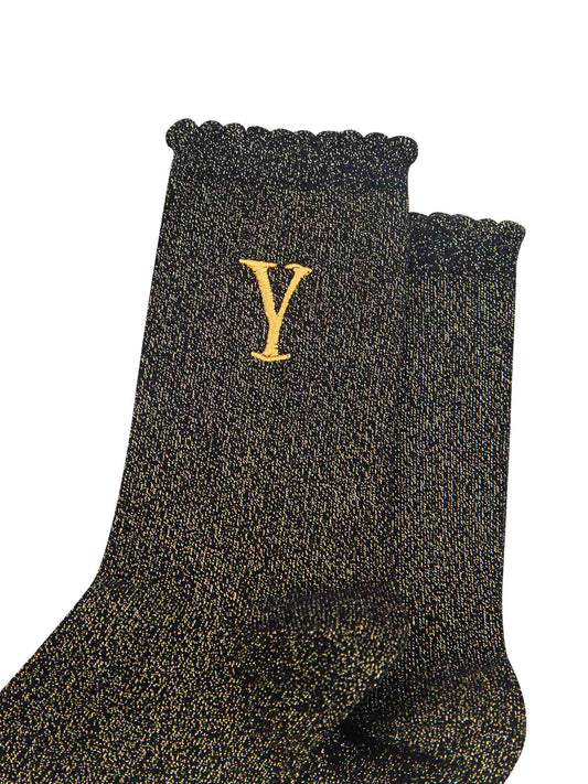 close up of the gold embroidered capital letter y on the ankle of the socks