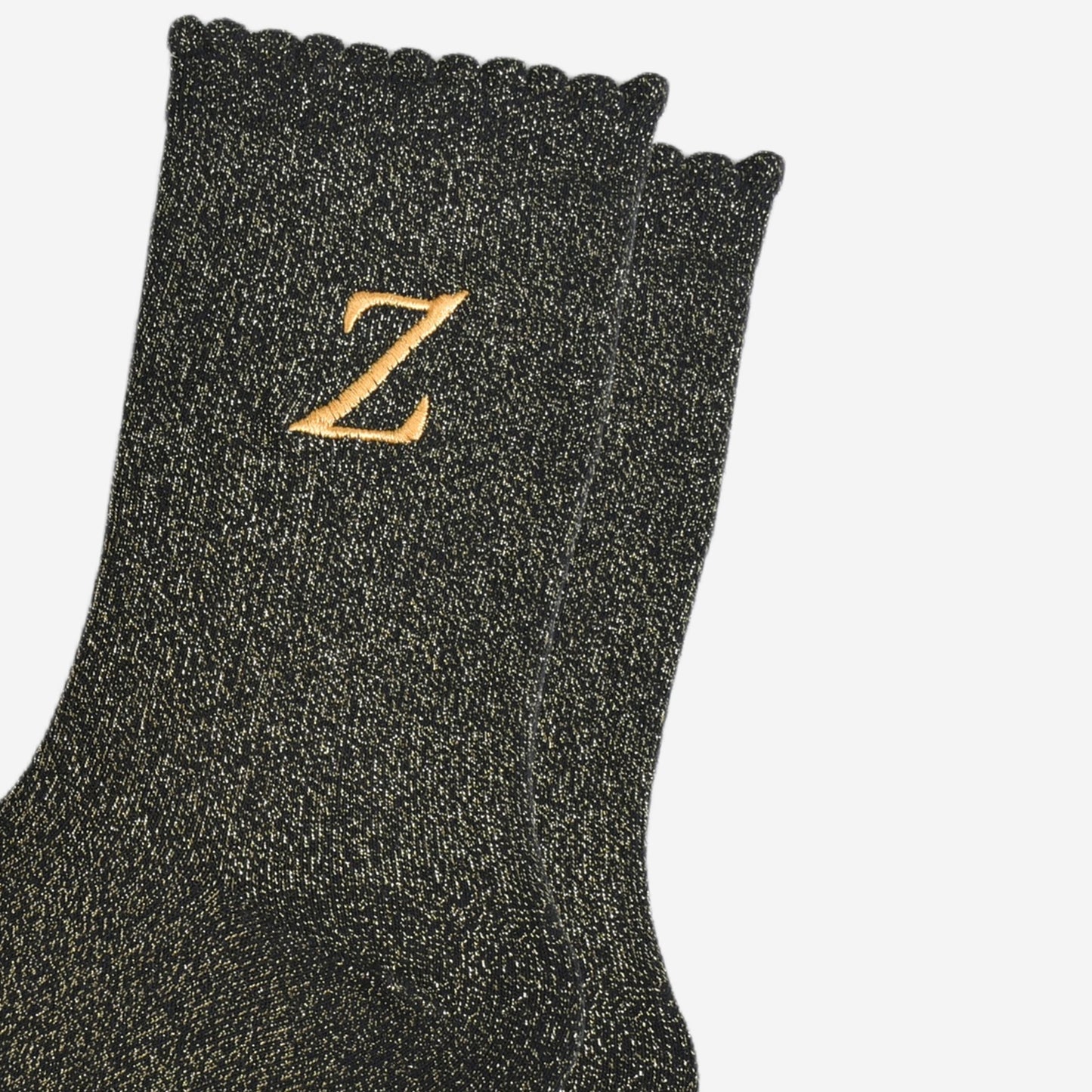 close up of the gold embroidered capital letter z on the ankle of the socks