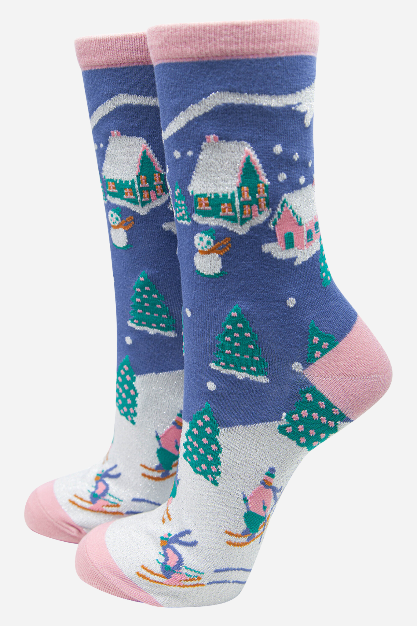 blue and pink bamboo socks designed with a winter ski village scene on them, featuring xmas trees, chalets and skiers