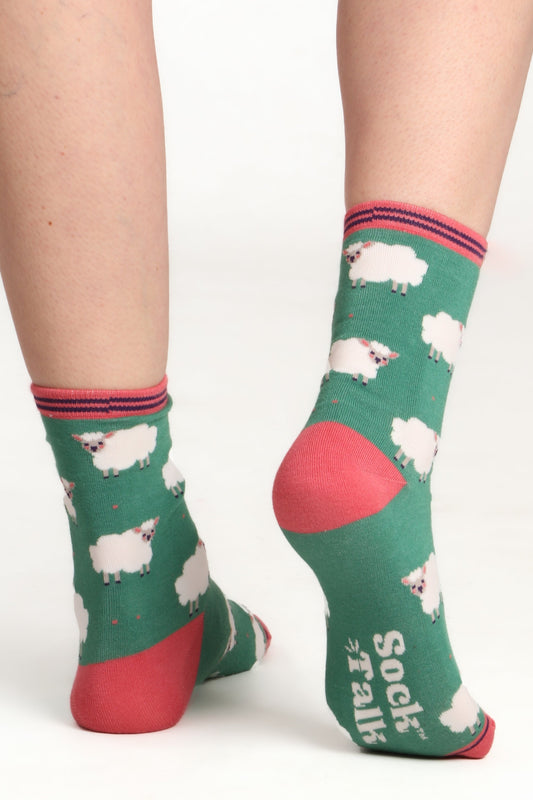 Laides feet facing away from camera wearing sheep lamb print bamboo socks. Image highlights the sock alk logo on sole