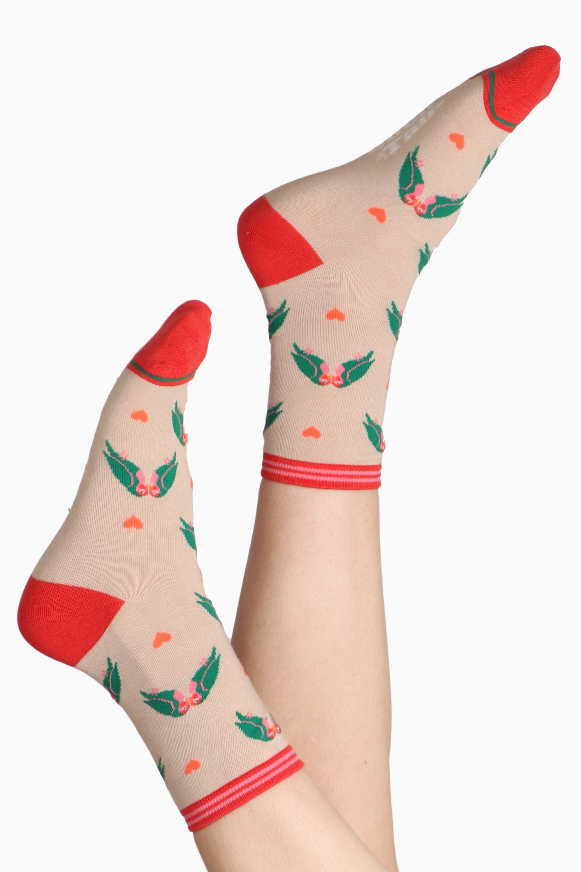Ladies feet in air wearing bamboo socks. Sock are printed with lovebirds on a cream base with a coral pinkey tone contrasting toe and heel