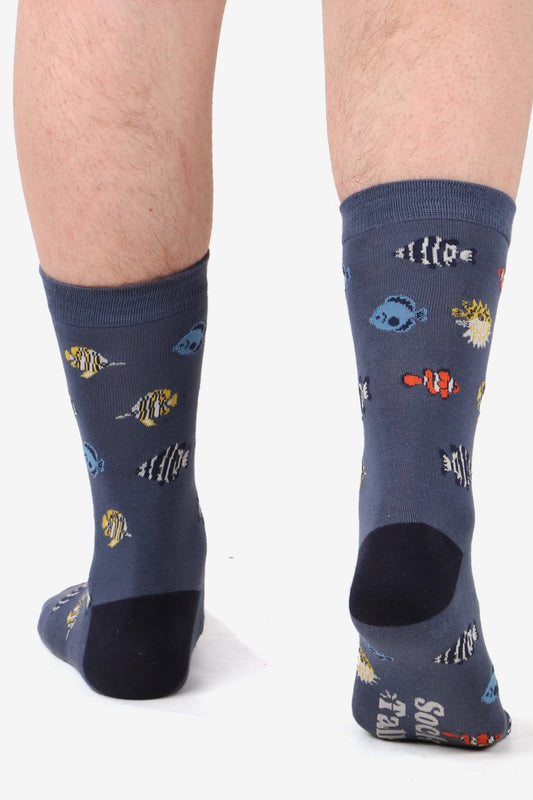 Men's fett walking away from camera wearing navy blue bamboo socks with tropical fish print. Sole of foot shows Sock Talk logo