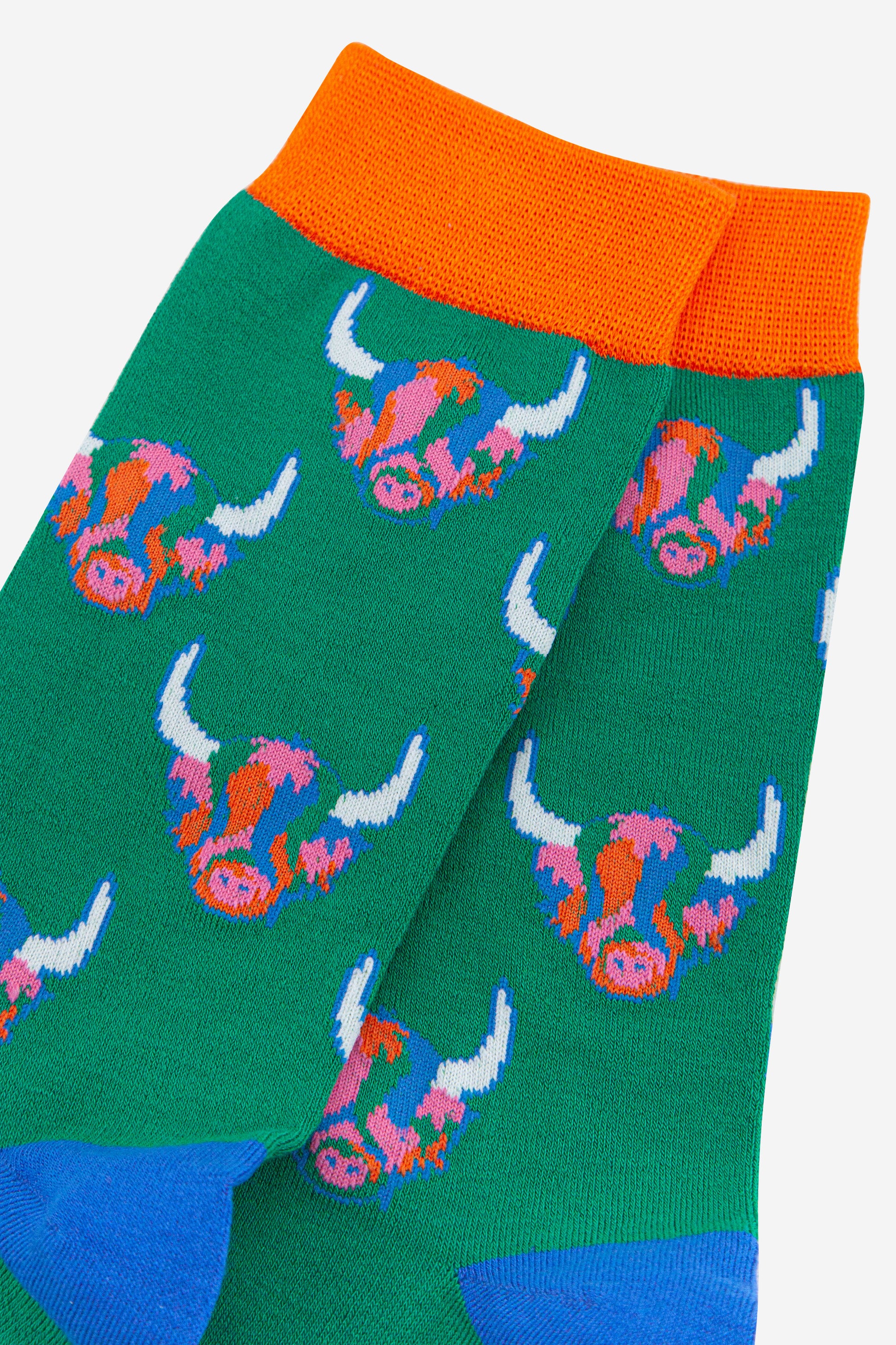 green bamboo socks with orange cuff and blue heel with an all over pattern of multicoloured highland cow faces