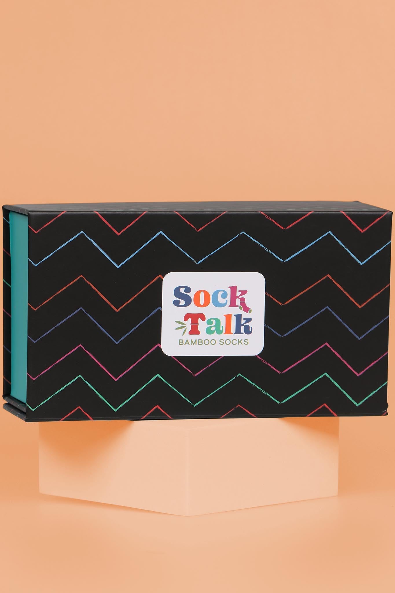 black sock gift box with a multicoloured zig zag striped pattern