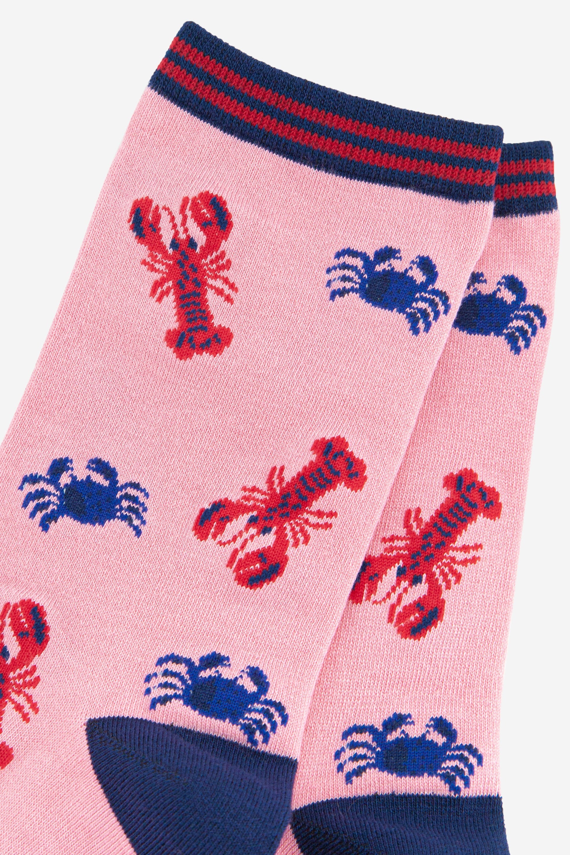 close up of the red lobster and blue crab print on the pink bamboo socks