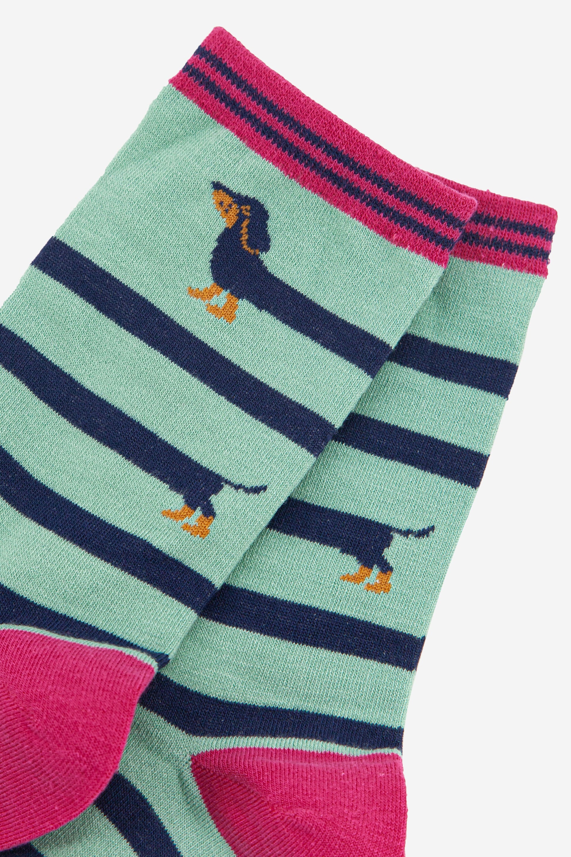 close up of the fun winding sausage dog pattern showing the head and tail of the sausage dog with its elongated body winding around the socks