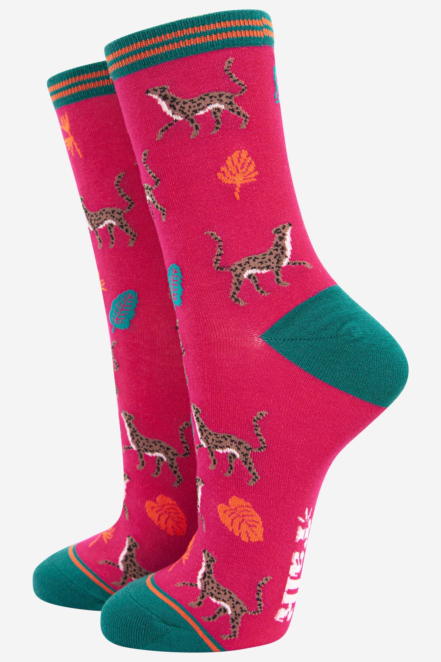 fuchsia pink bamboo socks with a green heel, toe and cuff featuring an pattern of cheetah cats and colourful jungle leaves