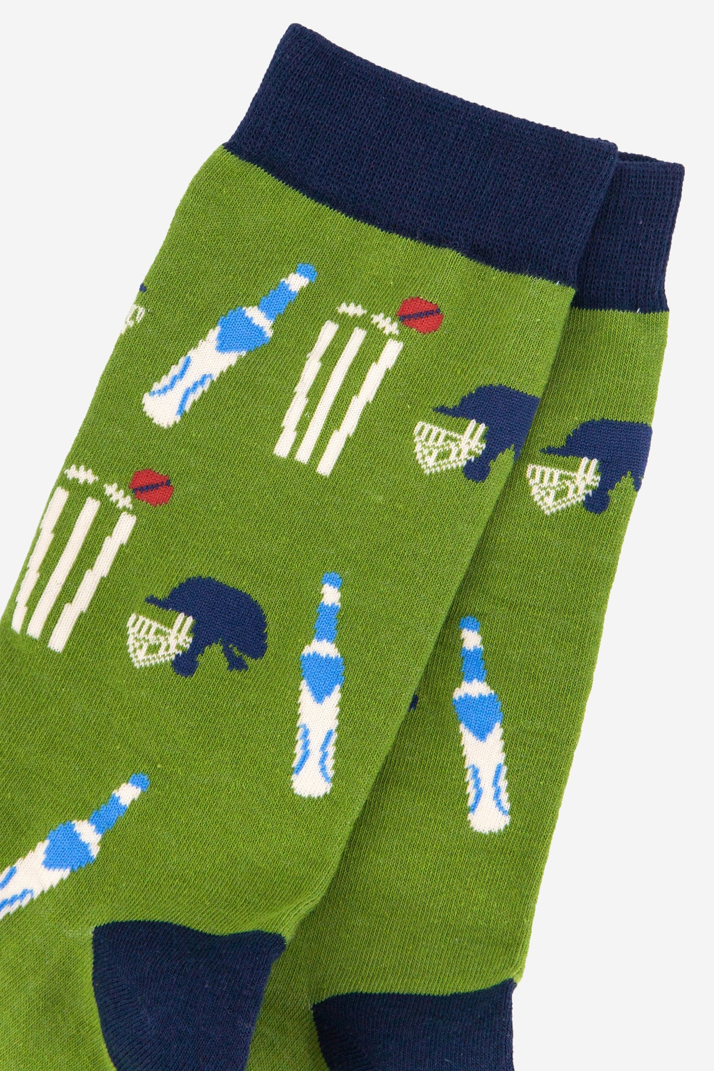 close up of the cricket kit pattern on the green bamboo socks, showing a cricket bat, stumps, ball and helmet