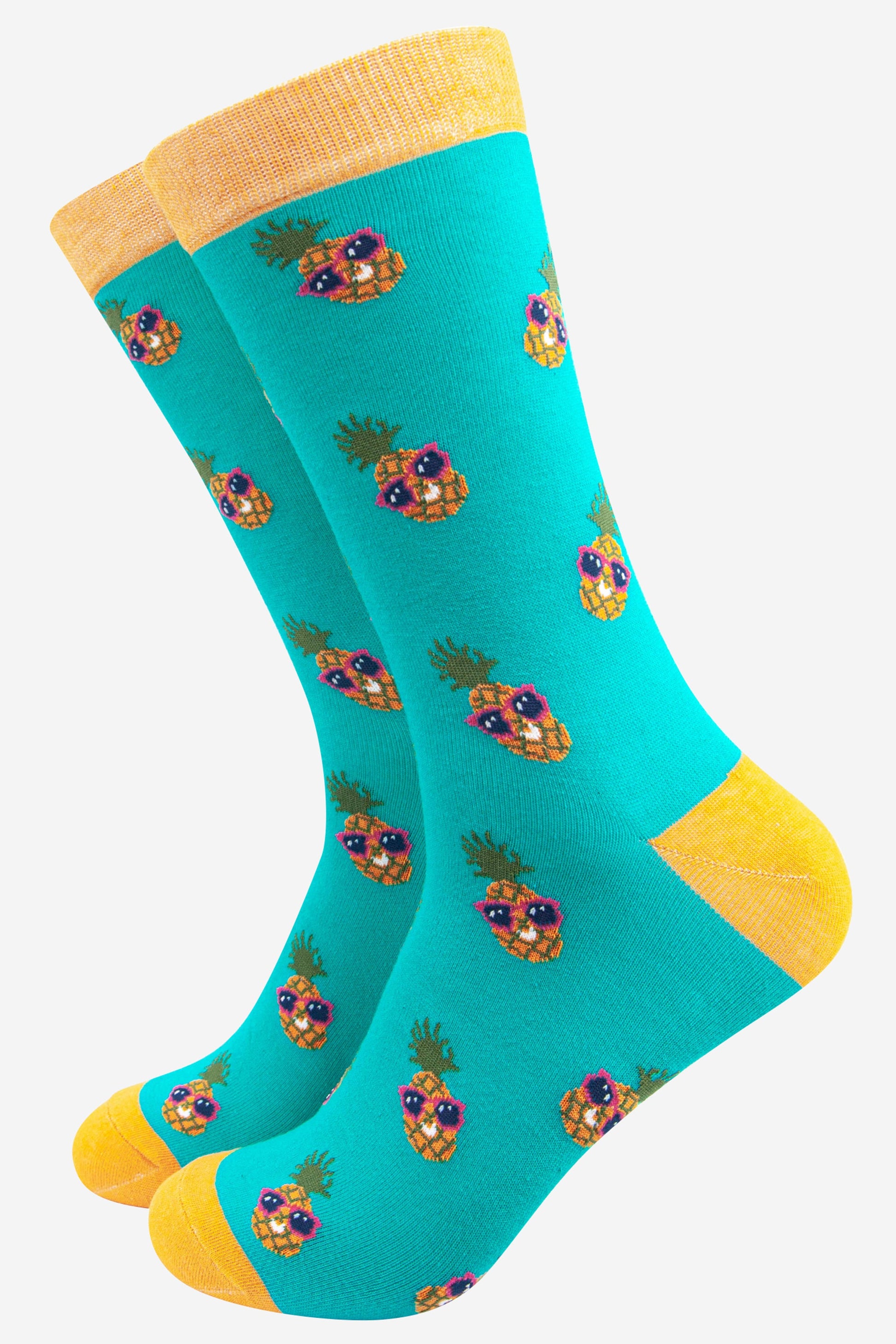 turquoise and yellow bamboo socks with an all over pineapple print, the pineapples are wearing pink sunglasses