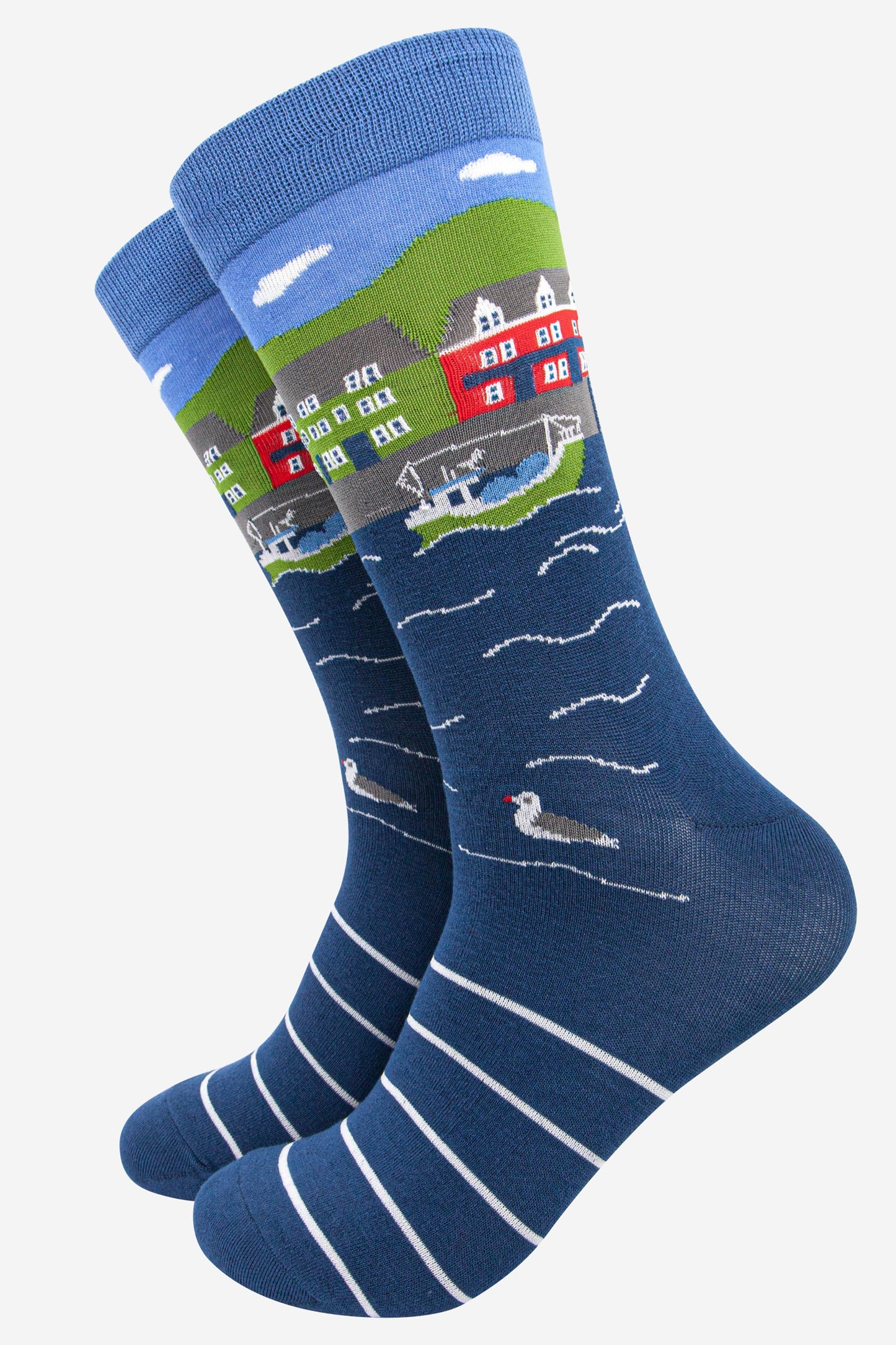 blue bamboo socks designed to look like a fishing village with a fishing boat, seagull and colourful houses beside a harbour
