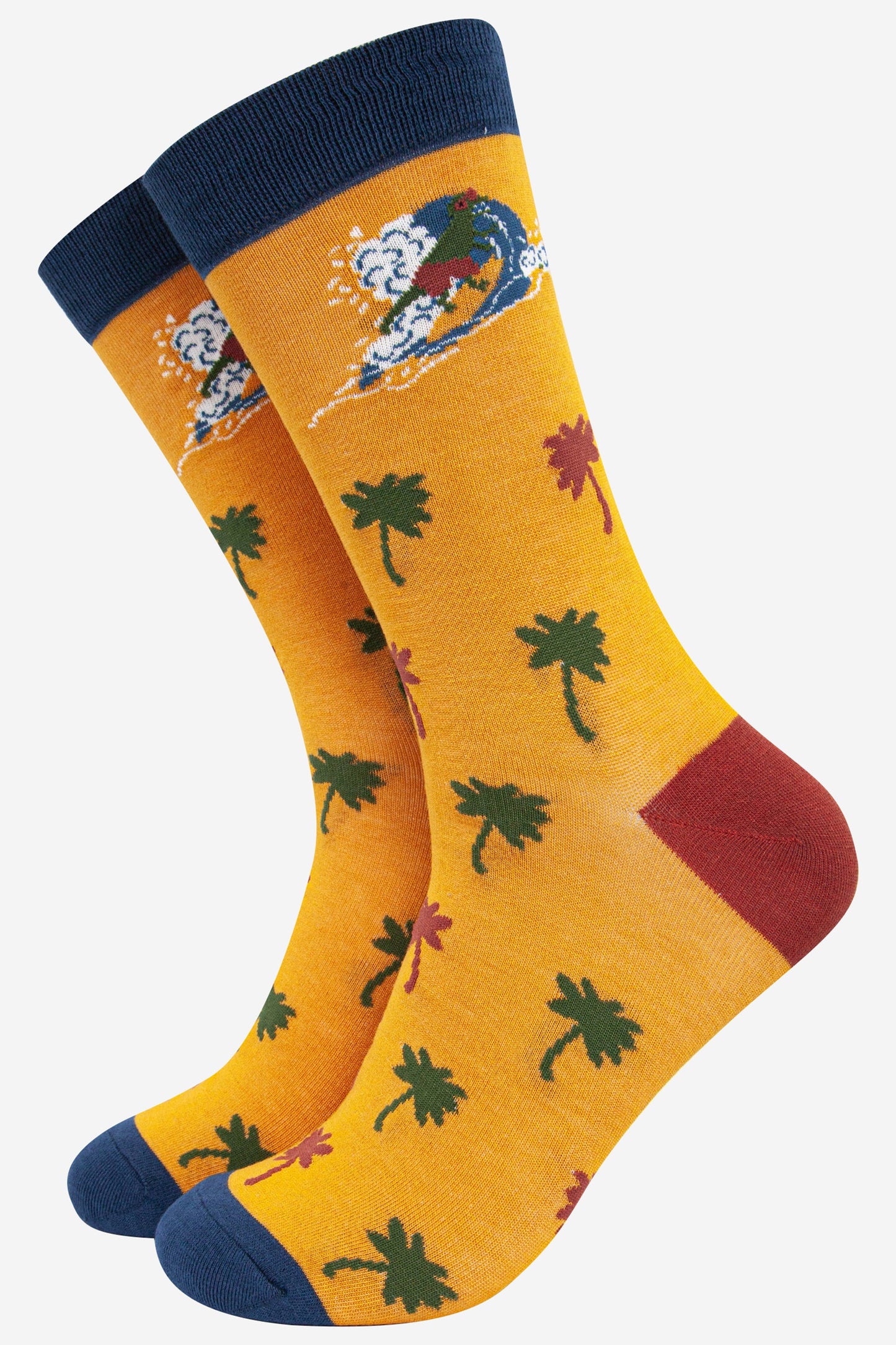 mens yellow bamboo socks featuring a surfing t-rex and an all over palm tree pattern