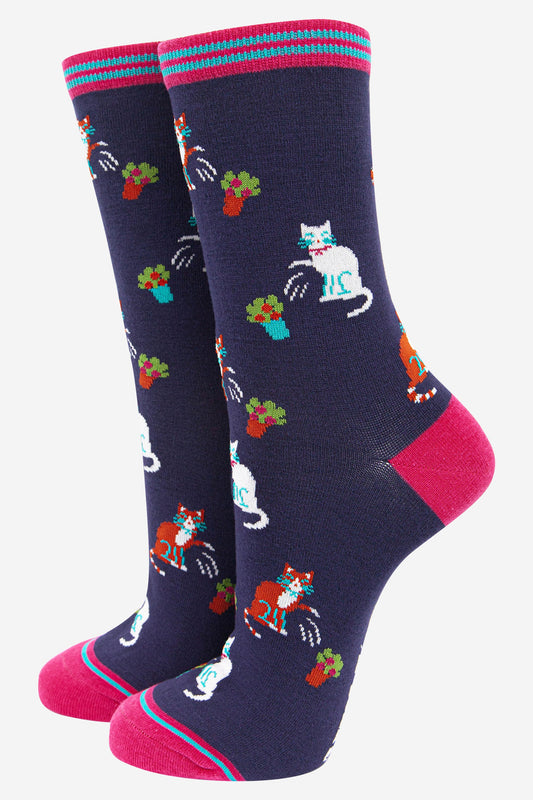 navy blue and pink bamboo socks featuring a funny print with cats knocking over plant pots