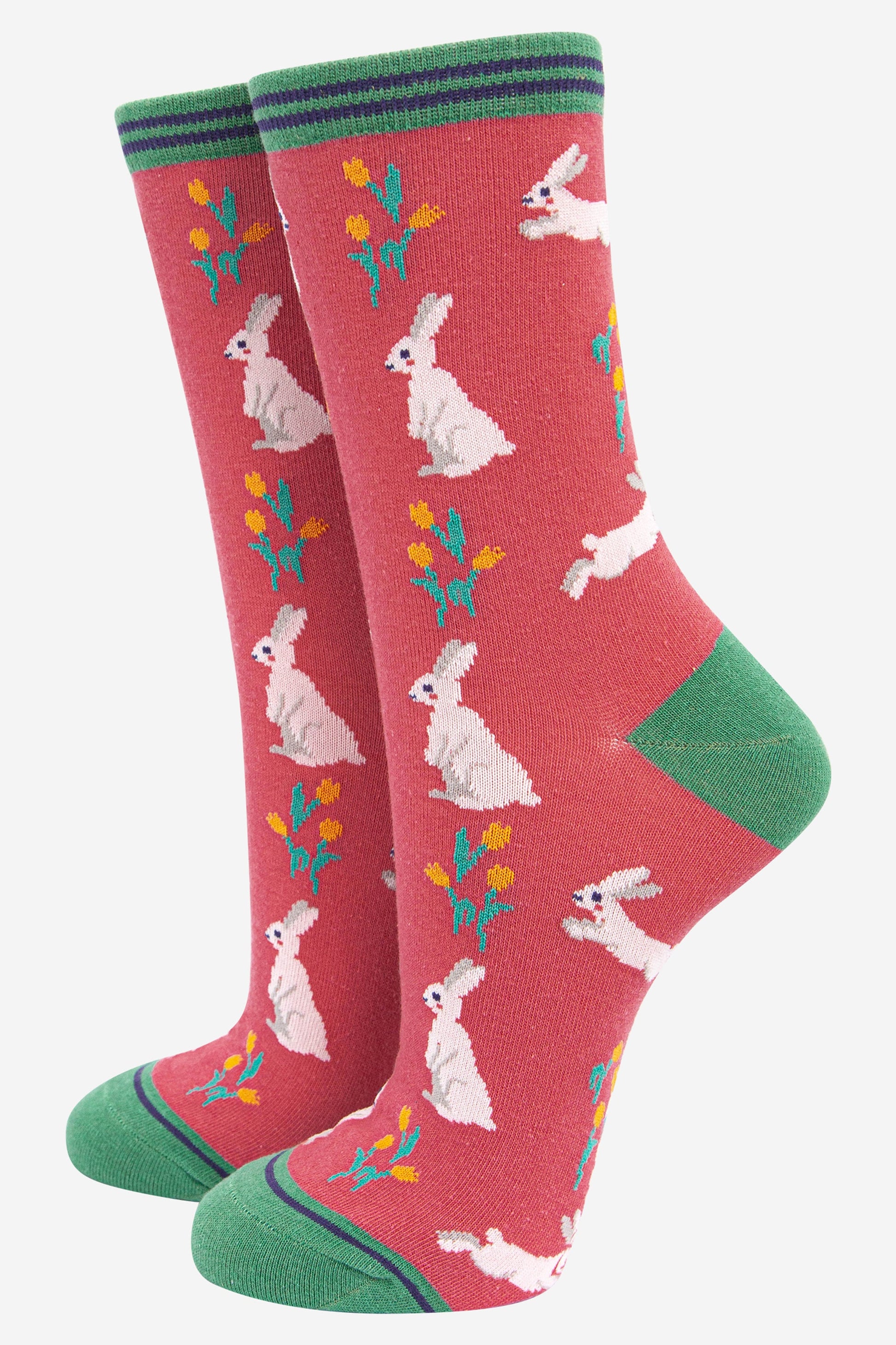pink bamboo socks with green heel, toe and cuff featuring white rabbits and yellow spring daffodils