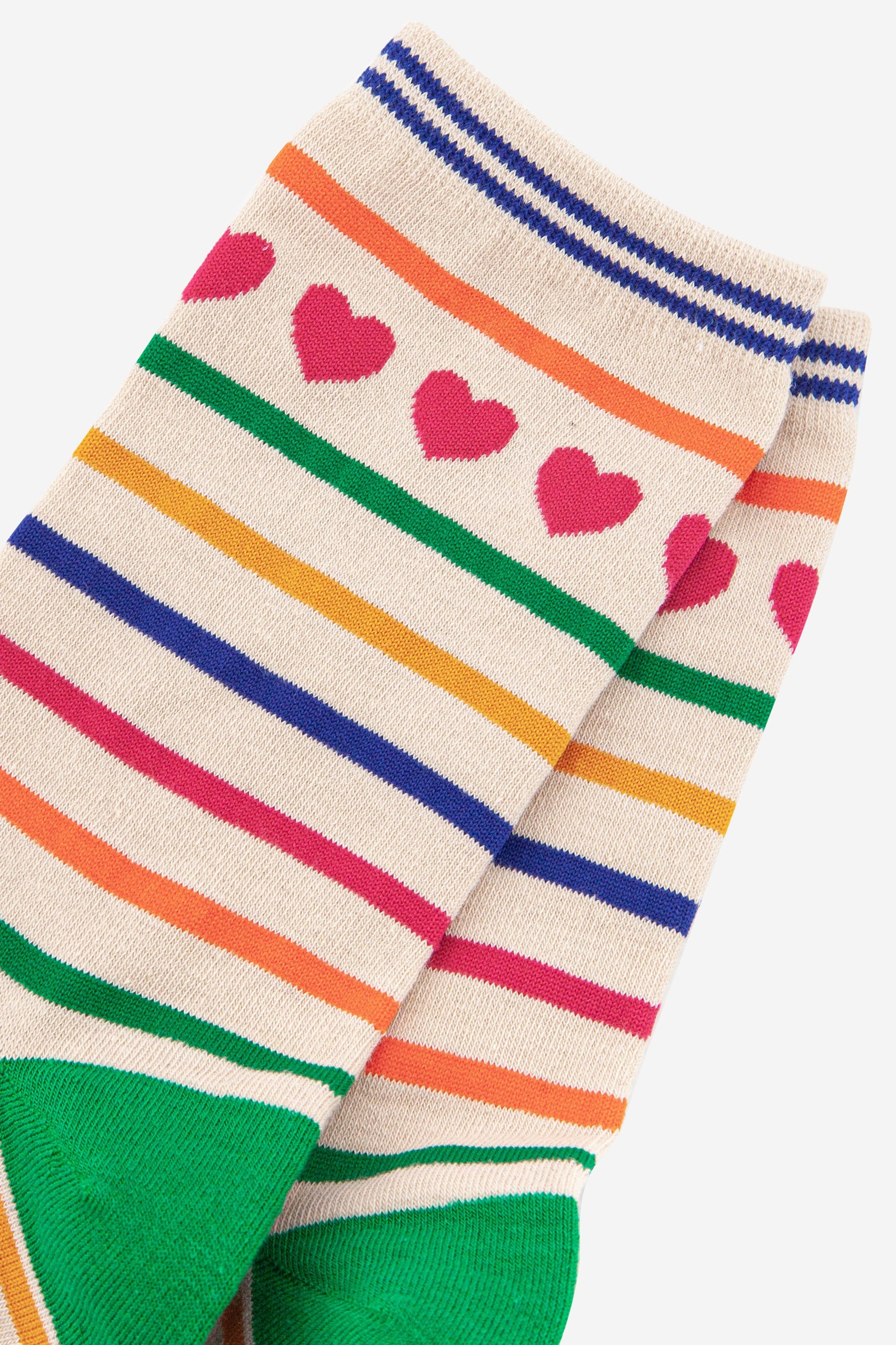 close up of the pink love heart detail around the ankle and the multicoloured rainbow stripes on the socks