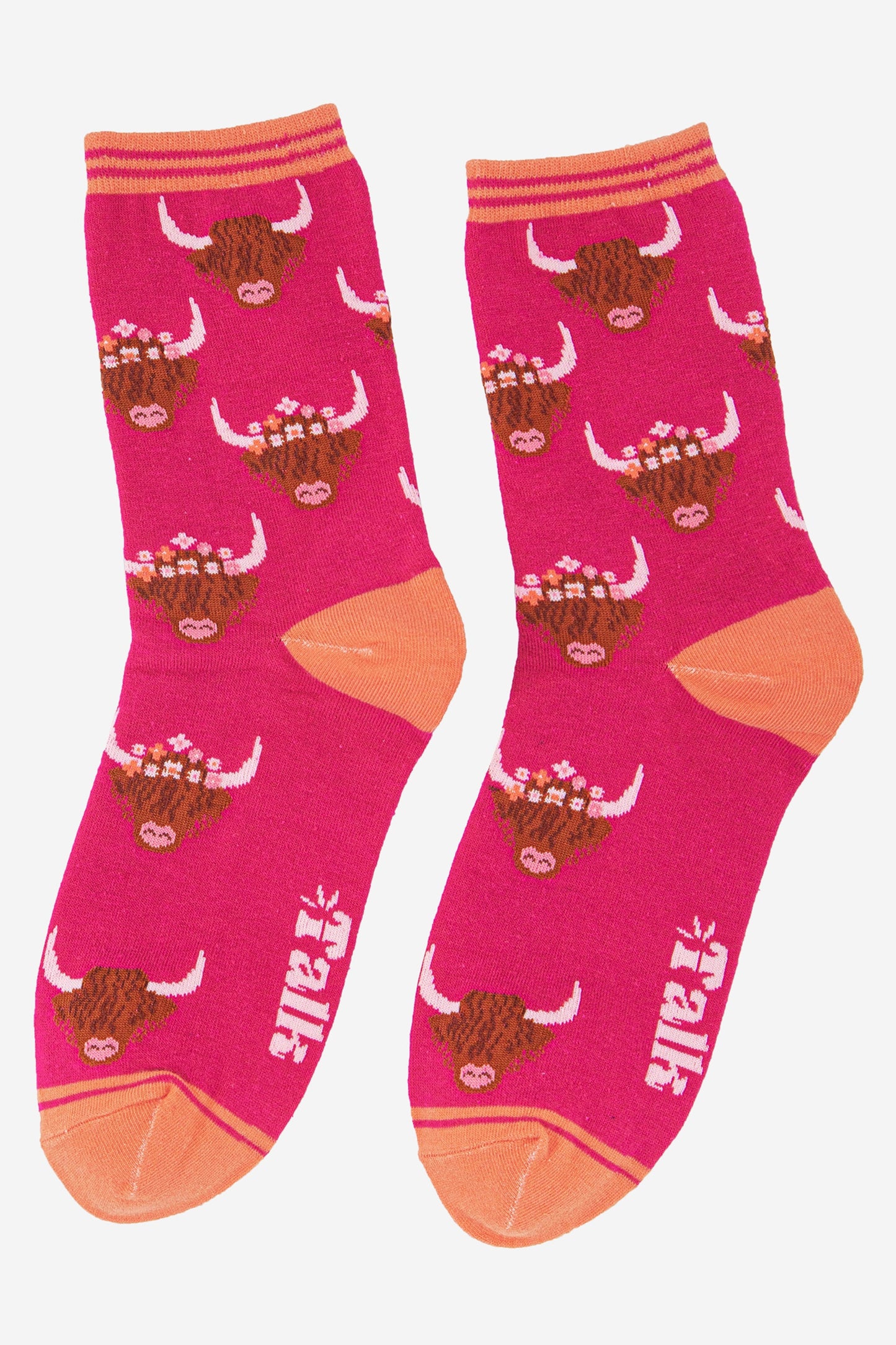 fuchsia pink bamboo socks with a pale orange heel, toe and cuff featuring a highland cattle pattern