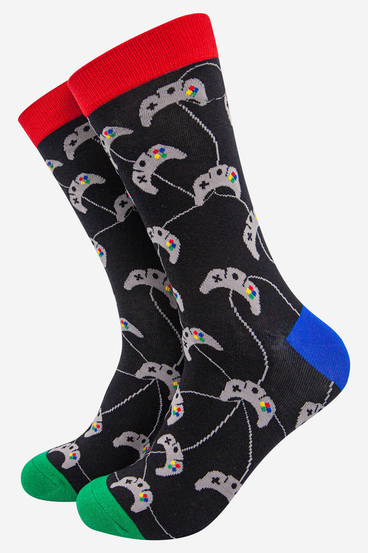 black socks with an all over pattern of grey game controllers with red cuff, blue heel and green toe