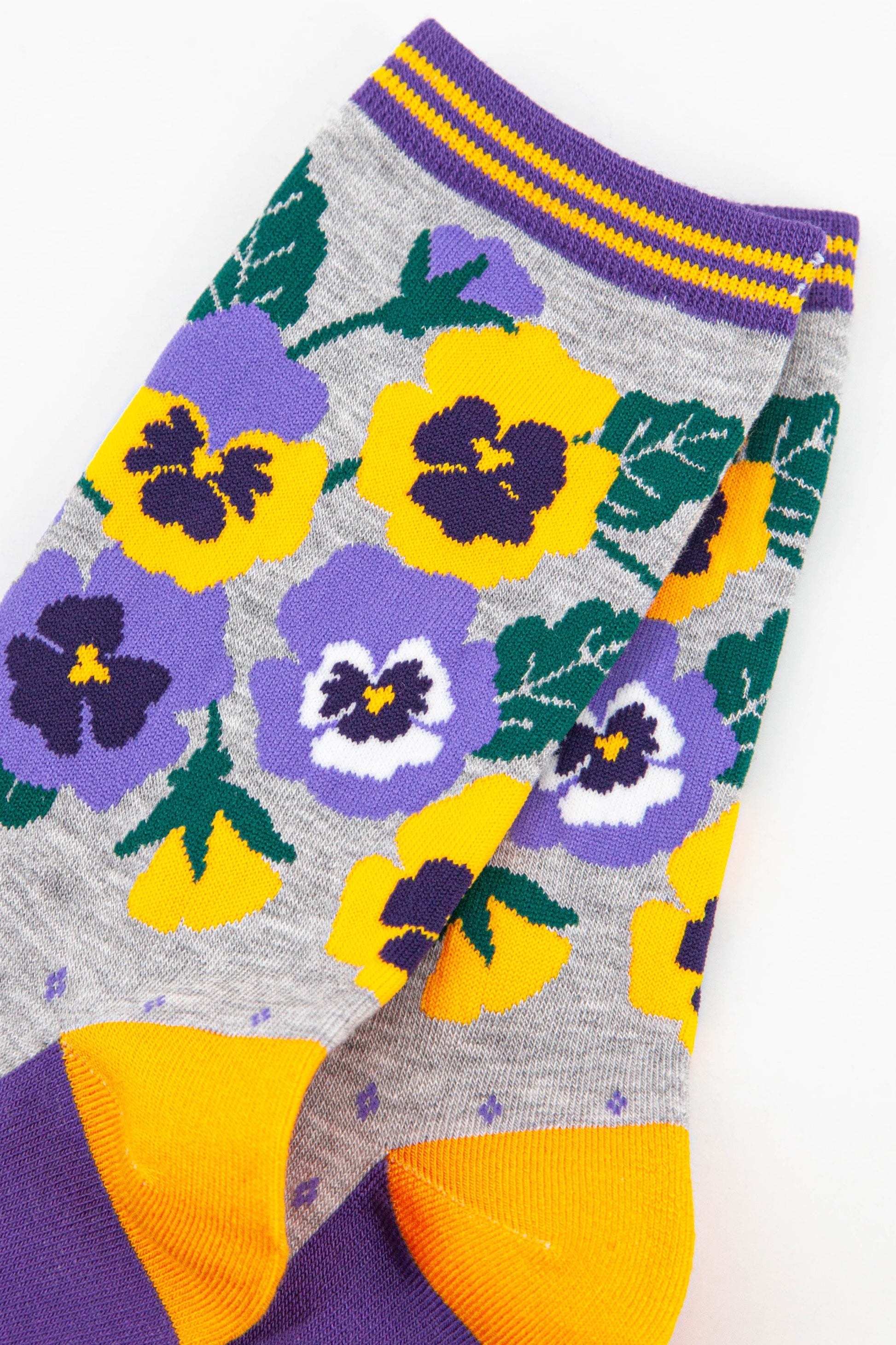 close up of the yellow and purple pansy flowers on the ankle of the bamboo socks