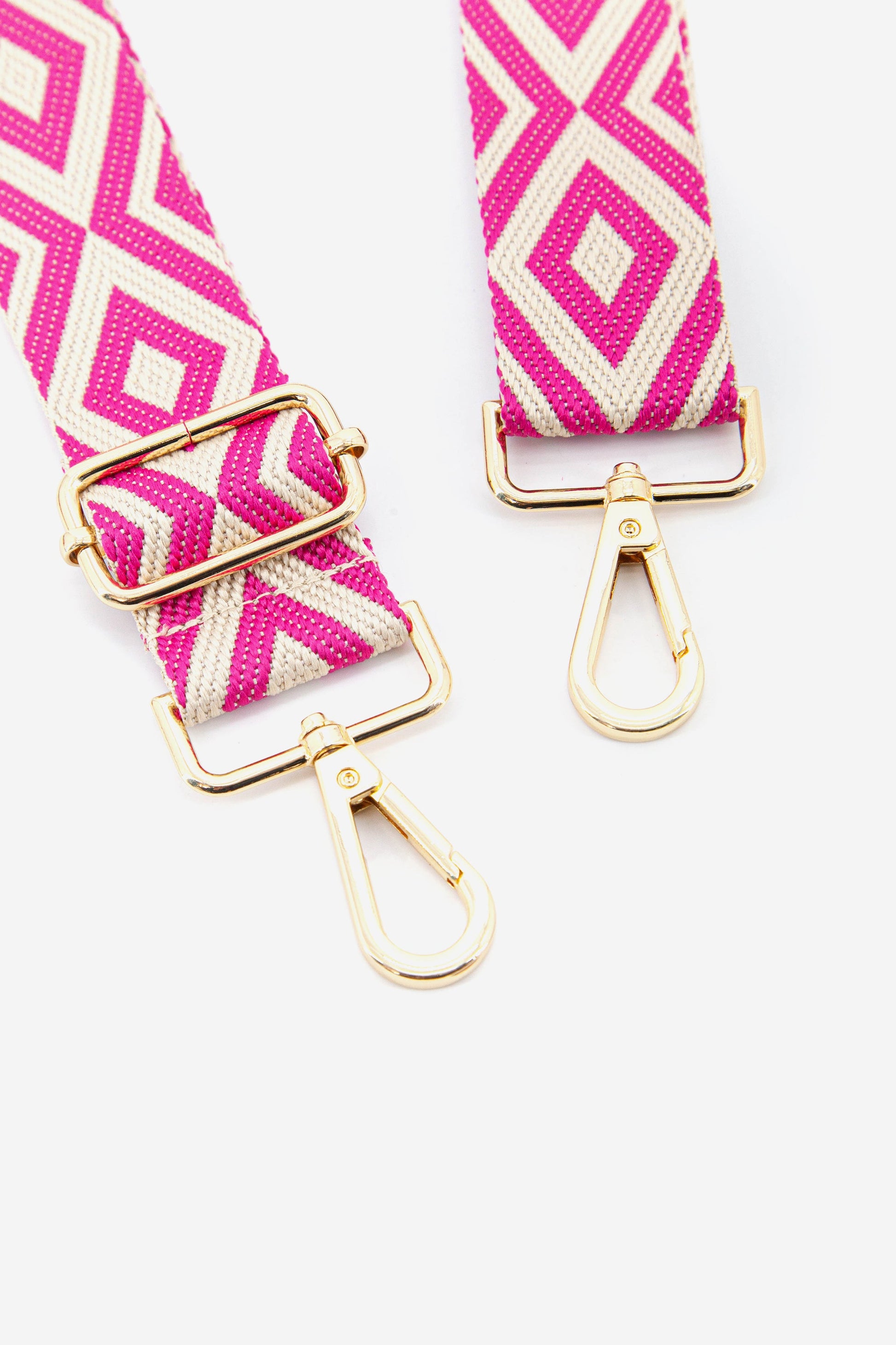close up of the gold snap hooks and the pink geometric pattern