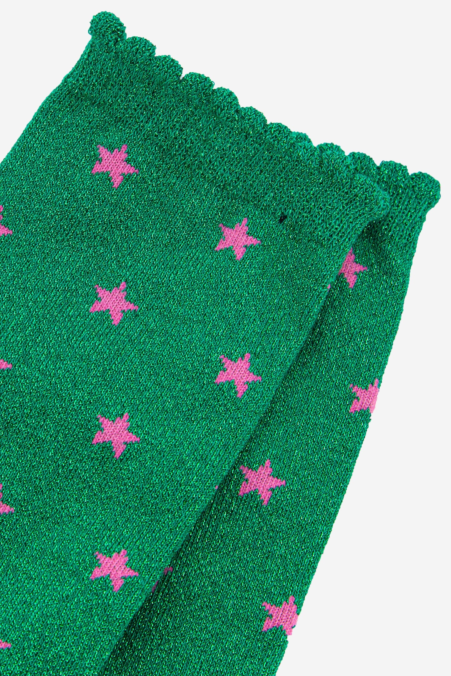 close up of the pink star pattern on the green glitter socks
