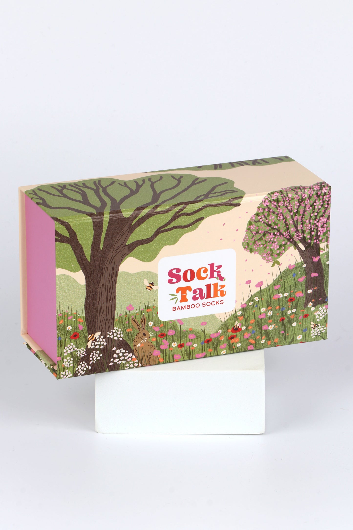 a sock gift box designed to look like a woodland meadow in summer, with flowers, bees and cherry blossom trees