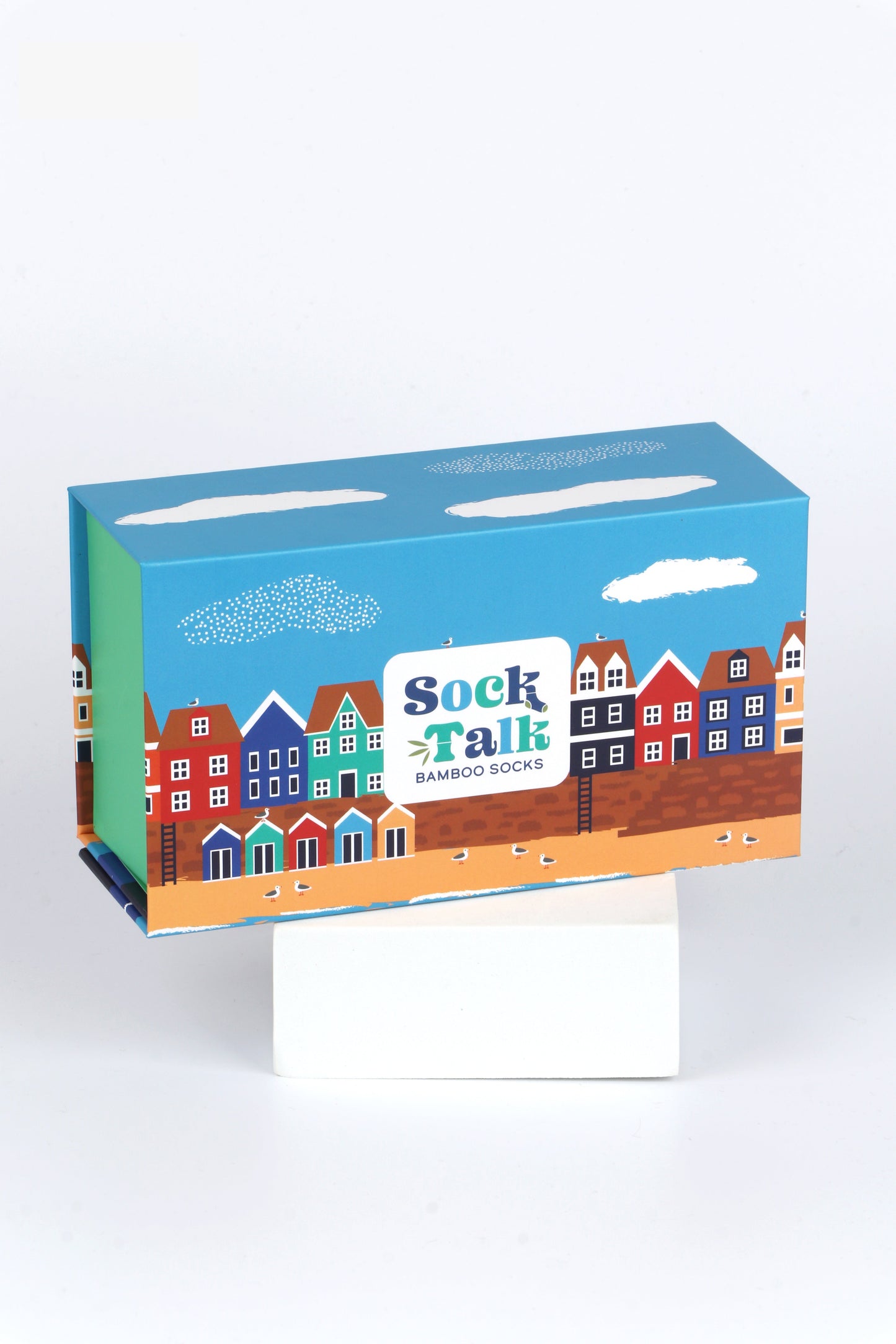 sock talk gift box designed to look like a seaside town with a beach, beach huts and colourful houses along the boardwalk