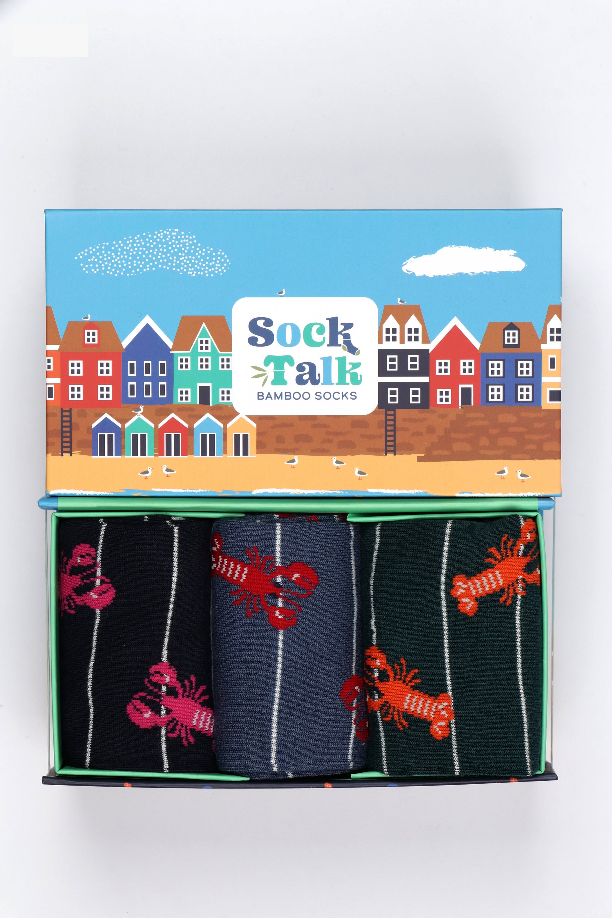 an sock gift set with three pairs of mens striped lobster socks in a gift box designed to look like a seaside beach scene