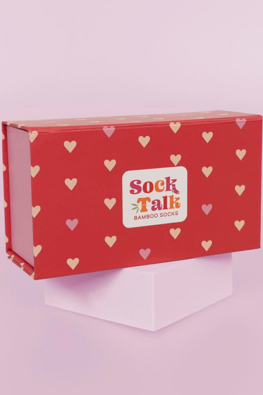 red sock gift box with an all over pink love heart pattern