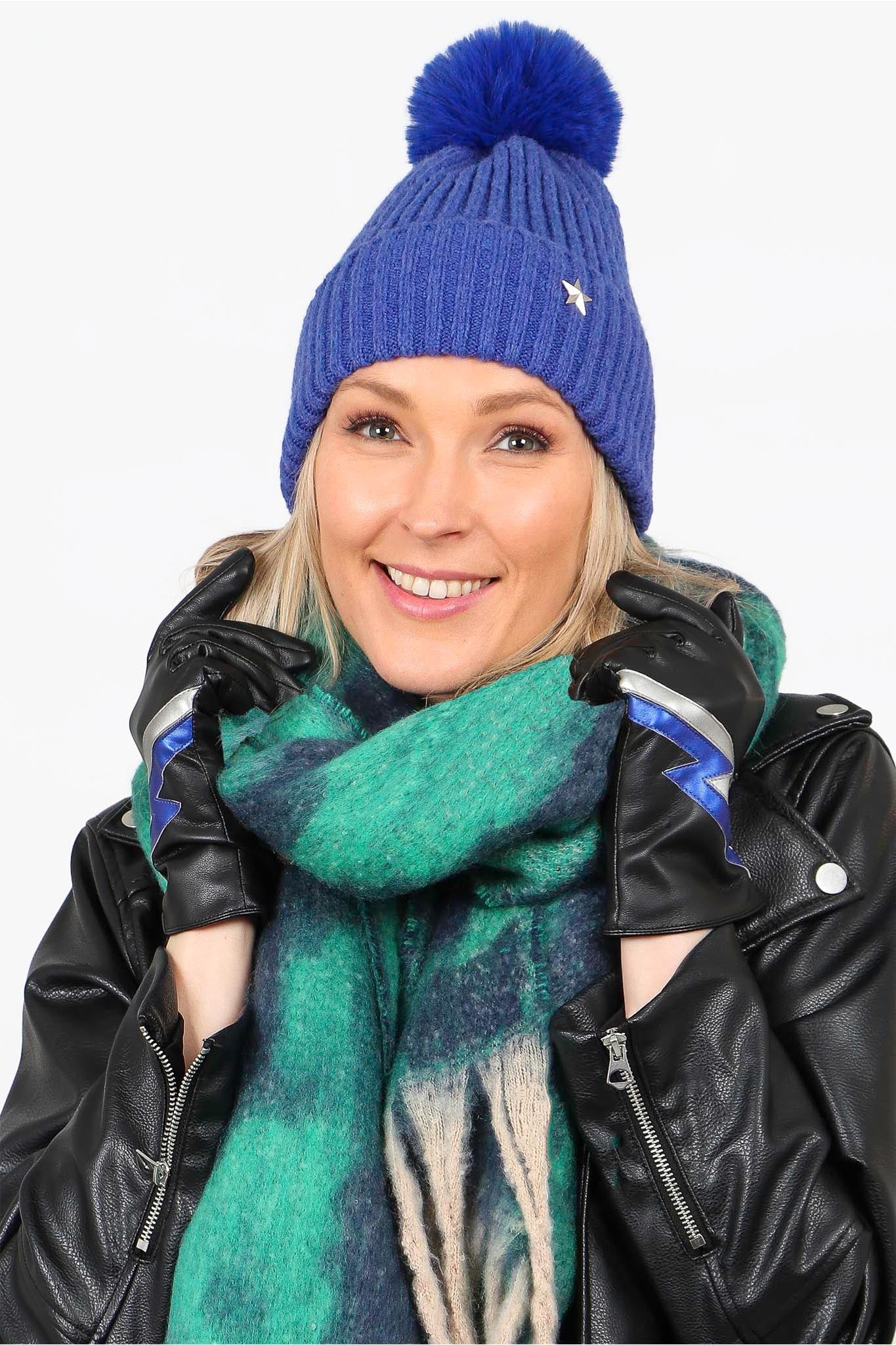 model wearing the black and blue lightning bolt gloves and other matching winter accessories